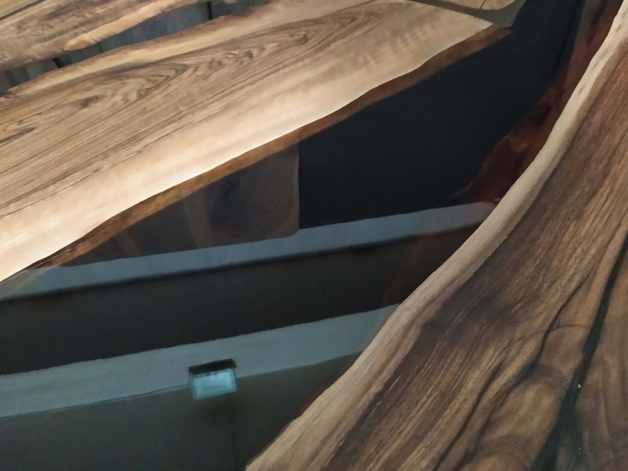 Close-up detail of transparent black epoxy resin river in a live edge wood table.