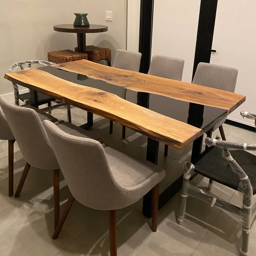 Live edge black epoxy dining table set for an elegant dinner party.
