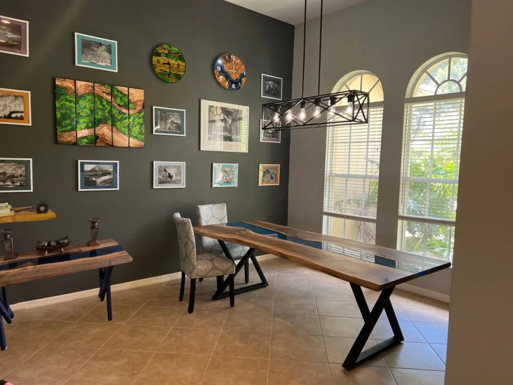 A curated collection of handcrafted walnut furniture, modern home decor including an epoxy dining table, a live edge entryway table, floating shelves, moss wall art, and an epoxy wall clock.