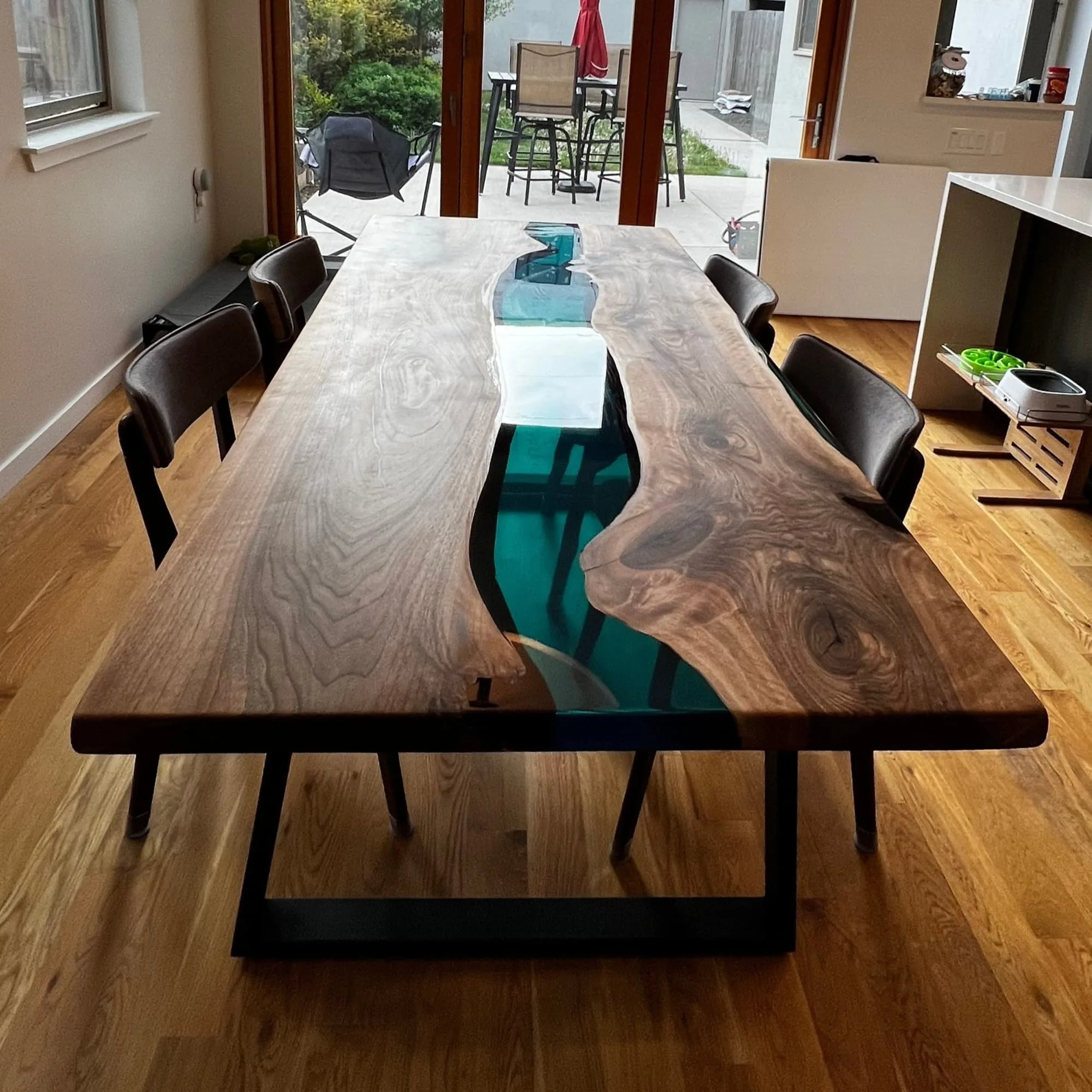 Custom transparent blue epoxy dining table in modern interior