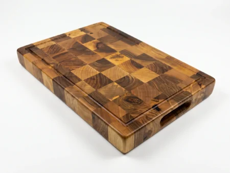 Handcrafted hardwood end grain board undergoing precision edge-routing and hand-sanding in artisan workshop.