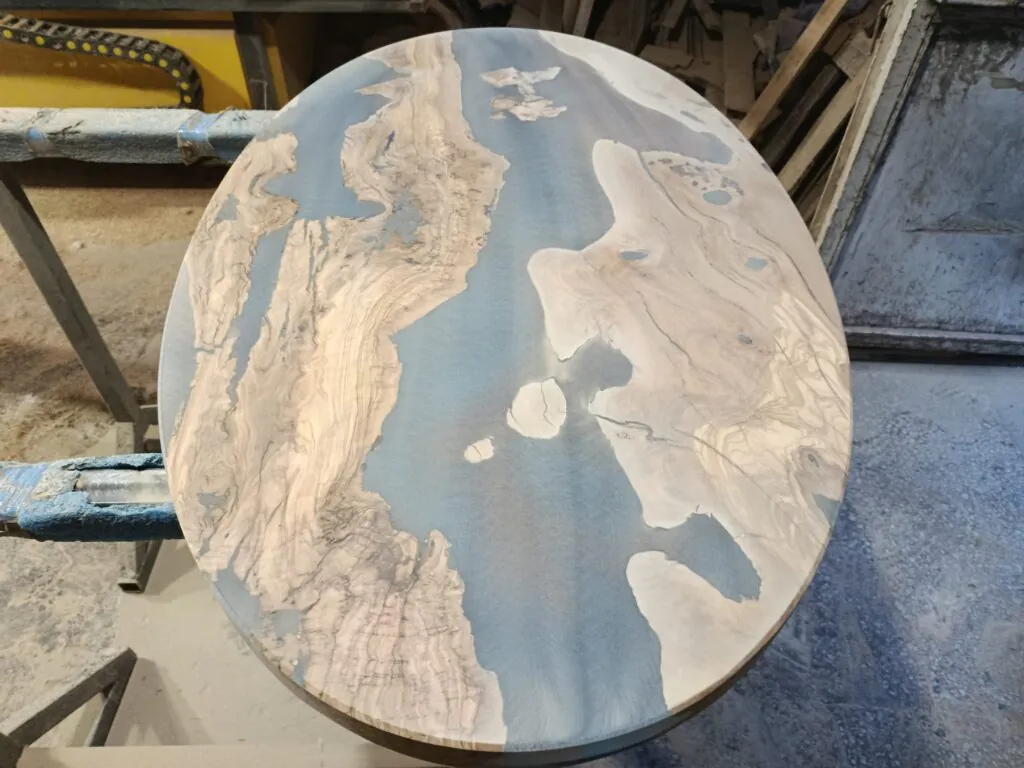 Oval epoxy resin coffee table handcrafted from olive wood - Levelling process
