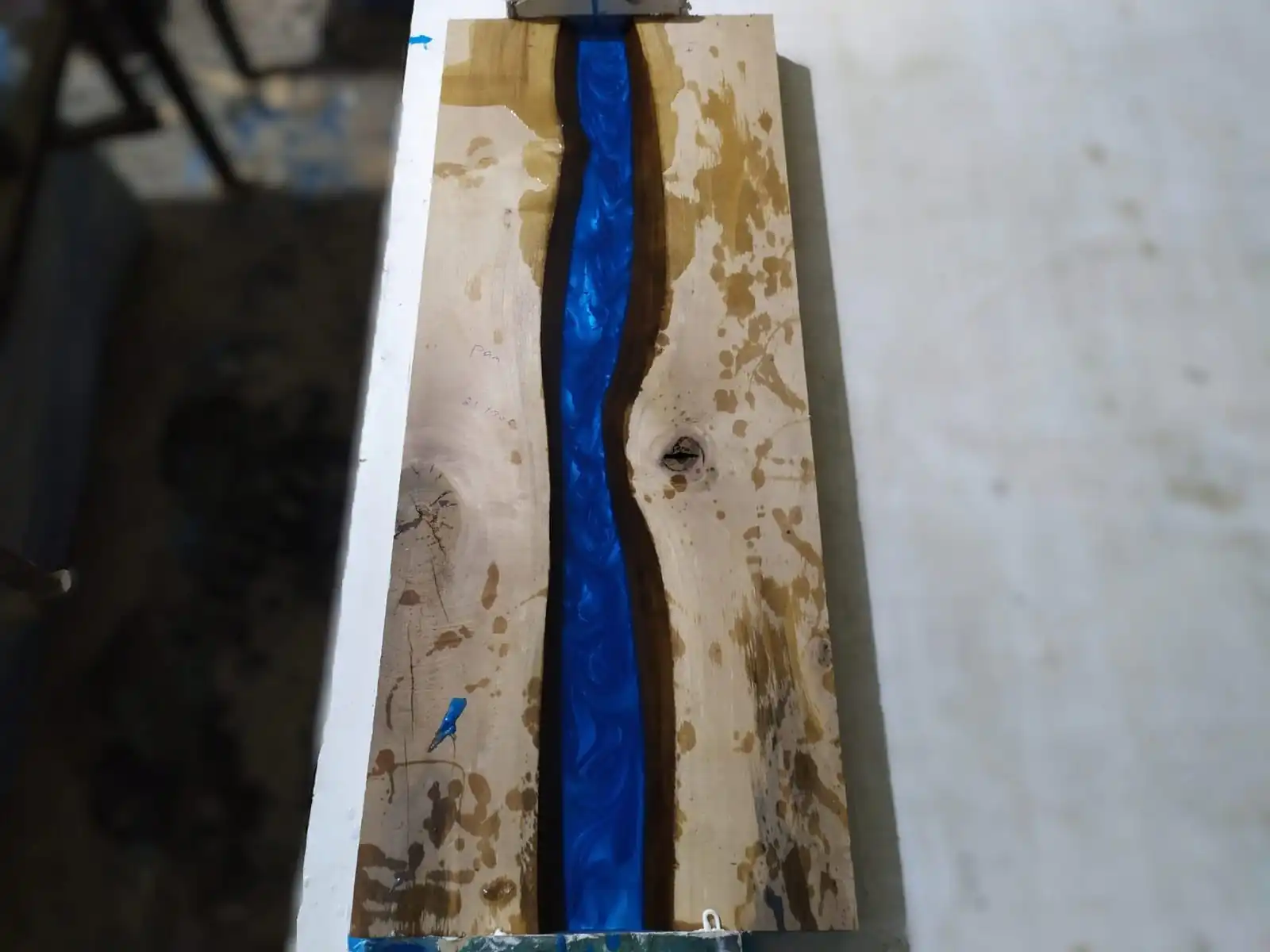 Master craftsmen carefully leveling the side edge profile of a custom Epoxy Console Table with Shelf.
