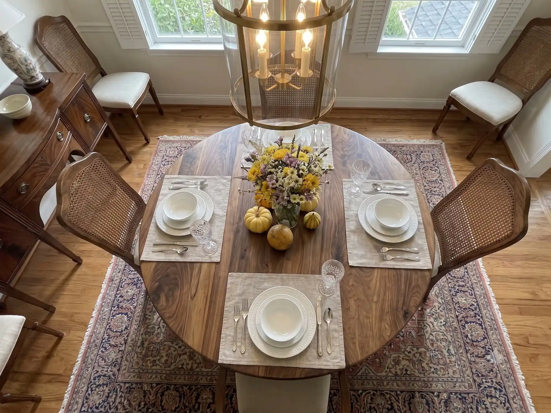 High-angle lifestyle perspective of the Round Walnut Dining Table surrounded by executive dining chairs.