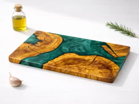 An overhead studio shot of a bespoke Olive Wood Epoxy Cutting Board showcasing wild olive grain and custom liquid resin channels against a crisp white background.