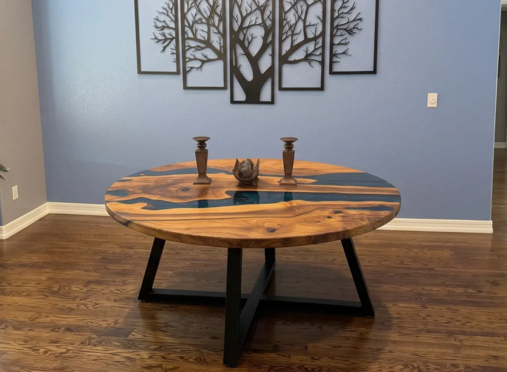 A unique round epoxy river dining table featuring a blue epoxy river design through a wooden surface.